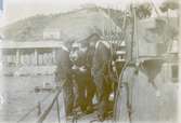 Gruppbild på varvspersonalen vid ubåten HVALENs torn. Varvet Fiat-San Giorgio i bakgrunden. Fotograferat från aktern.