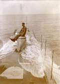 En man sitter på förliga manluckan vid överspolning till sjöss. Ubåten HVALEN.