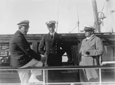 De båda männen t v är, liksom båten, oidentifierade. T h ses med cigarett och KSSS-mössa Evert Taube.