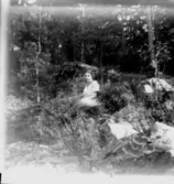 Sittande kvinna i skogen.