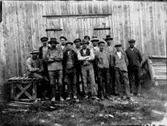 Yrkesgrupp, 13 män framför byggnaden.