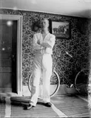 Rumsinteriör, en man.
En cykel vid väggen.