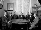 Längbro Arbetslöshetskommitté, interiör, sju herrar runt bordet.
Ordförande: folkskollärare Zakrisson, Törngatan 7, Nya Hagaby, Örebro.