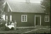 Dotorp, Brogärdet. Från vänster: Karl Gustavsson (1869-1957), fru Anna Sikberg på besök (1871-1949), Karls mor Maja-Greta Pehrsson,  (1835-1917, momor till Bertil Smedberg), Karls syster Elisabeth Gustavsson (1874-1944), Karls syster Natalia Gustavsson (1873-1957). Fotot taget omkring 1915. Lilla boningshuset fanns kvar 1973.