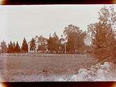 Stora Mellösa skola, tvåvånings skolbyggnader, Nya skolhuset.
Stora Mellösa kyrka i bakgrunden.