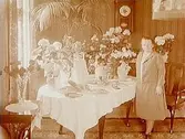 Rumsinteriör, en kvinna.Fru M. Carlströms 50 årsdag.