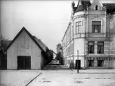 Tvåvånings bostadshus med torn och frontespis, Örebro Praktiska Språk och Handelsskola på andra våningen.
Köpmangatan söderut från Pumpkälltorget.