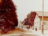 Tvåvånings träbyggnad.
Olaigatan västerut från Slottsgatan.
Reproduktion efter ett foto från 1900-talet.