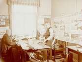 Interiör av redaktionen på Örebro Kuriren, två män vid ett skrivbord.