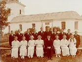 Konfirmander, 7 flickor, 10 pojkar och pastor Thorman.
Tysslinge kyrka i bakgrunden.