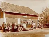 Tuna Brandkår, brandstationsbyggnad, sju brandsoldater vid sin brandbil av märket Packard.
