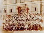 Olaus Petriskolan, realexamen, 26 flickor med blommor och ballonger på skolgården.
Fröken Svenssons klass.
