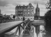 Gamla Vasabron i trä. Nikolaikyrkan. Till höger Telegraf- och Posthuset under byggnad.
Reproduktion 1939, efter en äldre bild från 1910-talet.