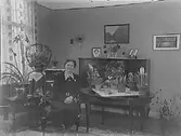 Fru Anna Erikssons 60 årsdag.Rumsinteriör, en äldre kvinna.