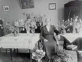 Fru Anna Hallkvists 60 årsdag.Rumsinteriör, en kvinna.