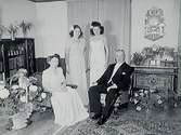 Fabrikör Edvin Sandbergs fru på 50 årsdagen.Rumsinteriör, familjegrupp fyra personer.