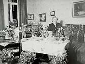 Fröken Anna Blomkvists 50 årsdag.Rumsinteriör, en äldre kvinna.
