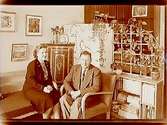 Rumsinteriör, två personer.
Ester och Fred A. Young, Highland Lake Co, Clearlake, Box 195, Californien, USA.