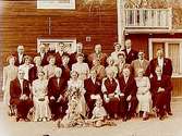 Bröllop, brudpar och bröllopsgäster. Bostadshus i bakgrunden.
Trädgårdsmästare P. Braun, brudens far, Röhammar, Stora Mellösa.
Midsommarafton 1949.
Brunnstorp, Adolfsberg.