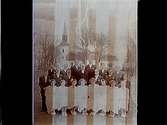 Kils kyrka i bakgrunden.
Konfirmander, 8 flickor, 12 pojkar och kyrkoherde Sköldebrand.
Pingstdagen den 13 maj 1951.