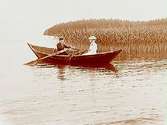 Två personer i en roddbåt (hjälmaresnipa ?).
Henning Andersson