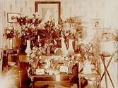 Rumsinteriör, silverbröllop, blommor i vaser.
J.E. Morän