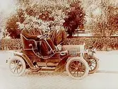 Örebros första övningsbil, automobil med två män i och en man utanför. 
Registreringsnr. T127.
E. Wern  (Troligen var det E. Wern, Storgatan 10, Örebro som beställde bilden)