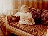 Ett litet barn i soffan.Elof Dahm
