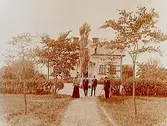 Marielund, Örebro öster.
En och en halvplans villa med frontespis, snickarglädje på förstubron.
4 personer framför villan.
A. Andersson