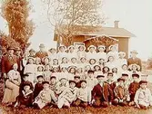 Vårdhems söndagsskola, 36 barn och 18 vuxna.
Envånings bostadshus i bakgrunden.
Ledare Johan Larsson.
