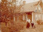 Envånings bostadshus, en kvinna med tre barn framför huset.
Herbert Johansson