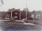 Tvåvånings bostadshus med glasad veranda. 
En och en halvvånings villa med burspråk och förstebro. En man med vattenslang.
Grosshandlare Uno Bergvall
