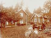En och en halvvånings bostadshus.
Fem personer framför huset.
Edv. Medin