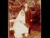 Brudpar, bruden helt i vitt, med myrtenkrona, brudgummen i bonjour.
John Johansson
