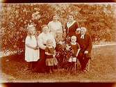 Familjegrupp 8 personer i trädgården.Kyrkoherde I. Jäderlund