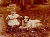 En liten flicka i barnstol och en Sankt Bernhards hundvalp.
Montör Nils Larsson