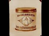 Karamellburk i plåt med följande text: Engelbrekts Äkta Bröstkarameller, bild: sjuksyster med en karamellburk.
Grosshandlare Uno Bergvall, Bergvall & Co Engrossaffär.