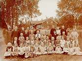 Bäcketorps skola, 44 skolbarn och lärare Knut J. Svensson med fru.Envånings vinkelbyggt skolbyggnad i bakgrunden.
