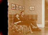 Rumsinteriör, 2 personer, Sven Lindskog och Dagmar Andersson.Sam Lindskogs familjebild.Två bilder på samma glasplåt.