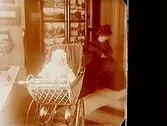 En dam, ett barn i barnvagn.Sam Lindskogs familjebild.Två bilder på samma glasplåt.