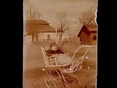 En baby i barnvagn.Bostadshus i bakgrunden.Sam Lindskogs privata bilder.
