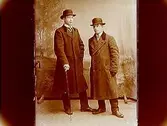 Två män i långrock och cubb.Ernst Almgren
