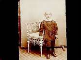 En liten pojke vid en stol.Alma Granfeldt