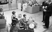 Krämaren 5 år 26 mars 1968

Krämaren firar 5 år som butik. Två män i kostym står framför två pojkar sittande i trampbilar med ballonger.
En flicka sitter på en gunghäst, och en annan flicka har en dockvagn.