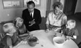 Barndaghem 9 september 1966

Vid ett bord sitter en förskollärare och en man i en svart kostym. De gör figurer med barnen av trolldeg.
