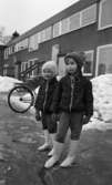 Gyttorp 2 23 februari 1967

Två flickor står på en gård. De är klädda i jacka, mösa och vita stövlar. Bakom dem finns en byggnad och en cykel. Dessutom höga snövallar.