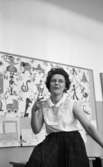 Kopparbergs skola, 1 mars 1967. En lärarinna som sitter i ett klassrum i en skola i Kopparberg. Hon är klädd i en vit blus och en svart veckad kjol. I bakgrunden hänger en anslagstavla med varje bokstav i alfabetet, barnteckningar m.m.


Fröken Karin Flodström
