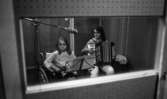 Spela in skiva. 25 september 1968

Bilden visar; två kvinnor i inspelningsstudio. Den ena kvinnan iirullstol den andra kompanjerar på dragspel.