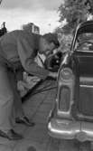 Arne Selmosson, 29 juni 1965

Fotbollsproffset från Götene tankar bilen.
Män vid bil på bensinstation.
