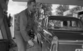 Arne Selmosson,  29 juni 1965

Fotbollspelaren Arne Selmosson vid bil på besinstationen. Kvinna i passagerarsätet.
Castrol